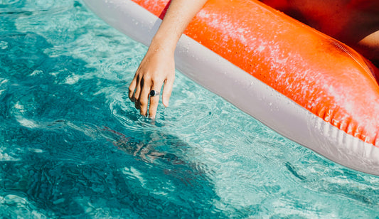 Person relaxing on an inflatable pool float in the water